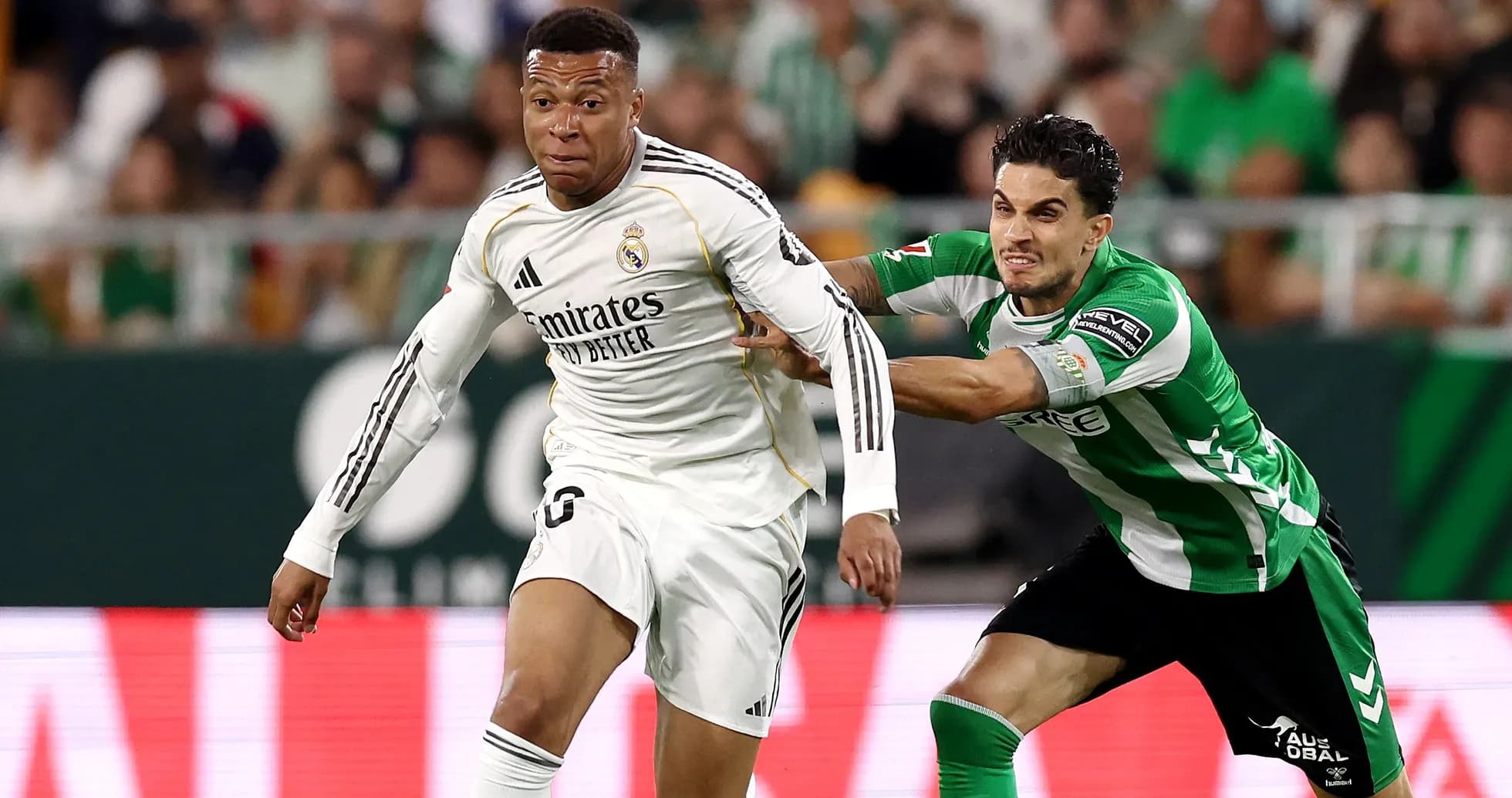 Jugador de Real Madrid driblando a oponente de Betis
