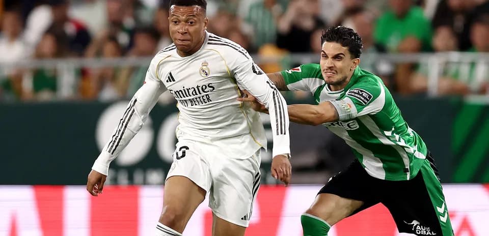 Jugador de Real Madrid driblando a oponente de Betis