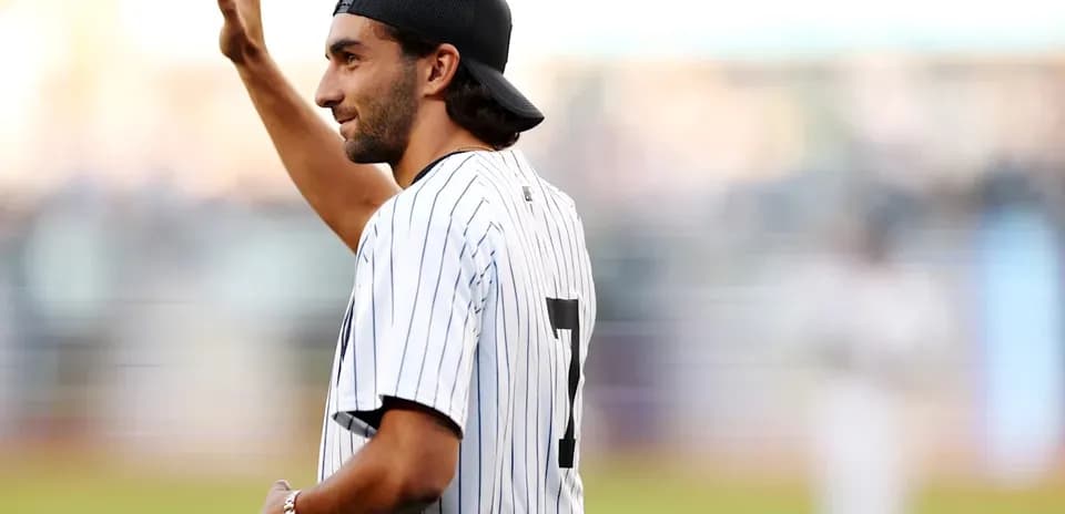 Persona saludando en el campo de béisbol