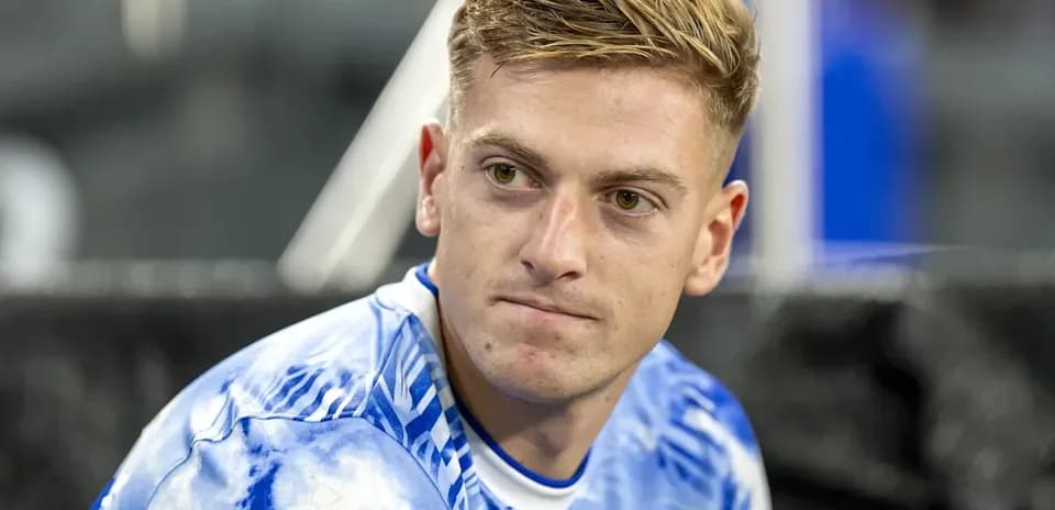 Jugador con camiseta azul sentado en el banquillo