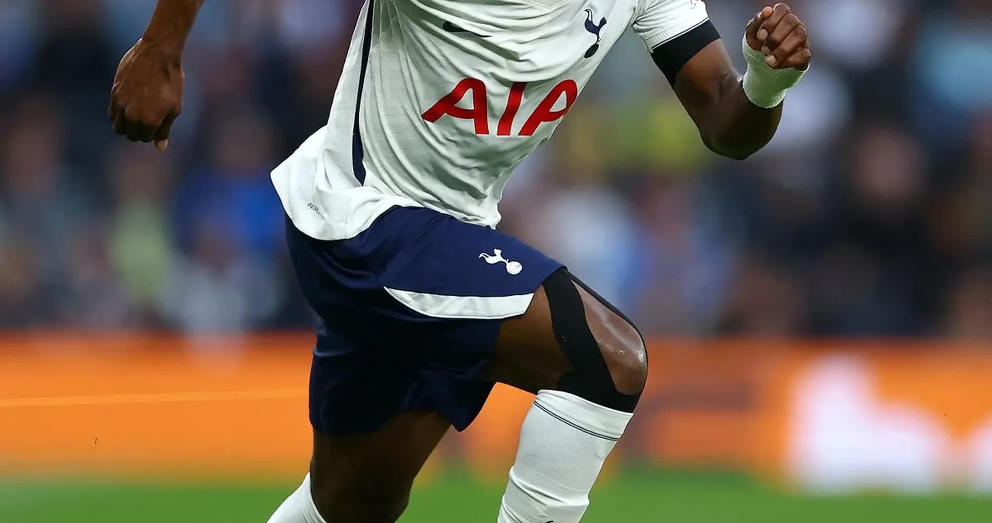 Jugador de Tottenham corriendo tras el balón en campo