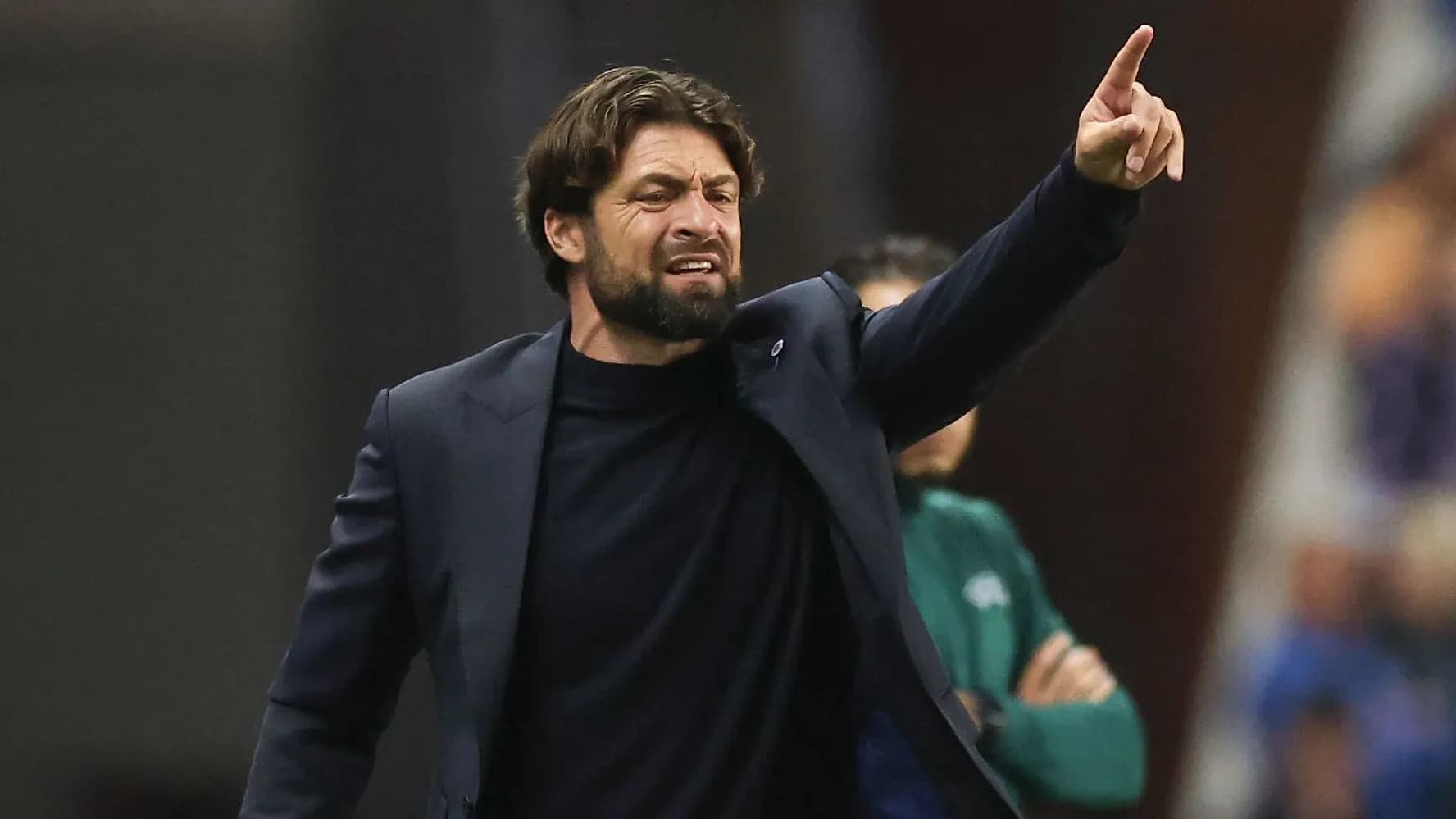 Entrenador señalando durante un partido de fútbol
