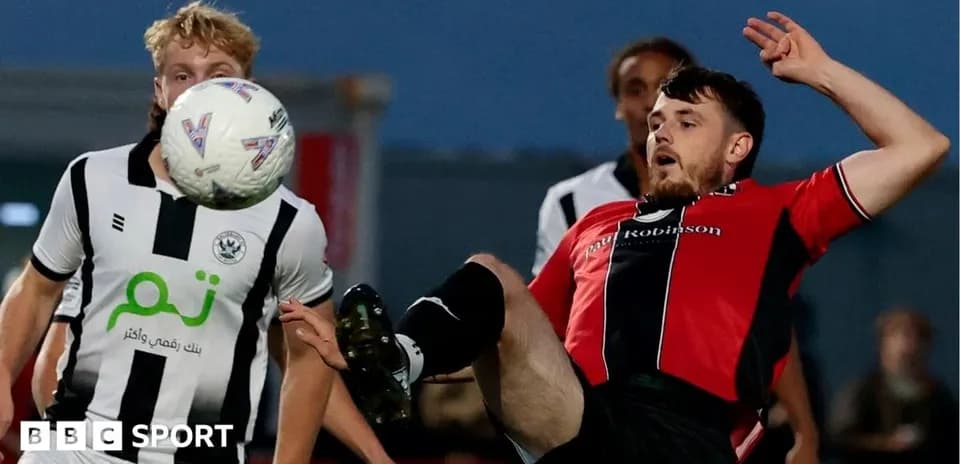 Jugador caído intentando controlar el balón en partido