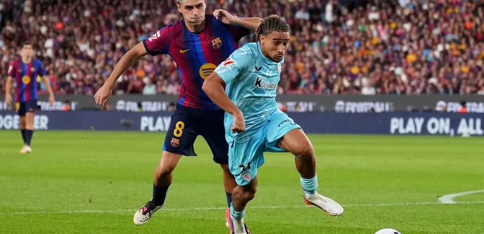 Jugador de Barcelona persiguiendo a oponente con balón