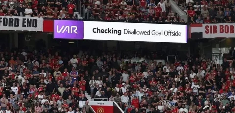 A crowd watching VAR decision for disallowed goal