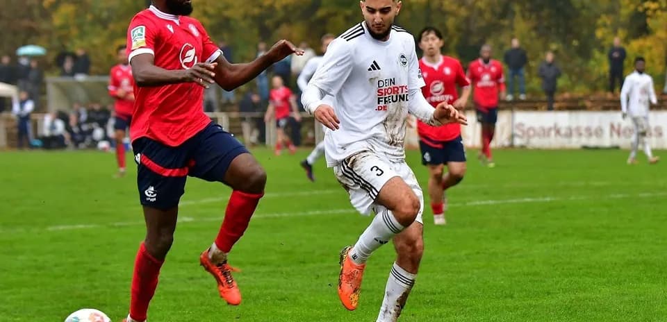 Jugador con camiseta blanca driblando a oponente