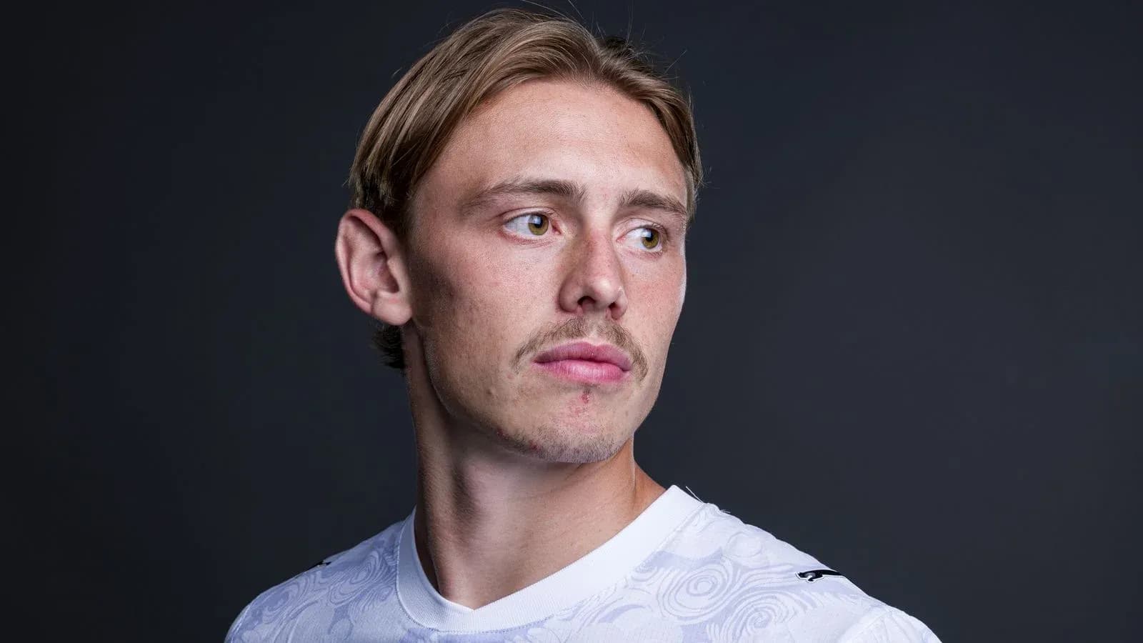 Jugador de fútbol posando con camiseta blanca