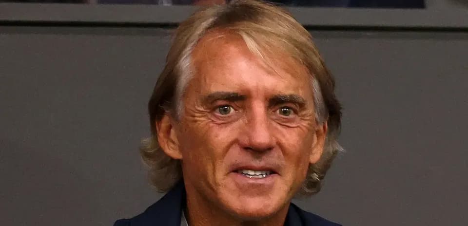 Entrenador sonriendo en la tribuna del estadio