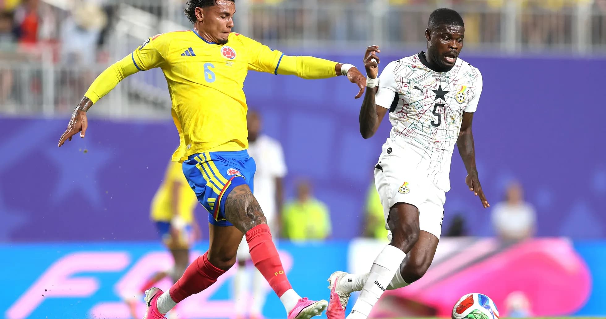 Jugador colombiano desafiando a oponente ghanés