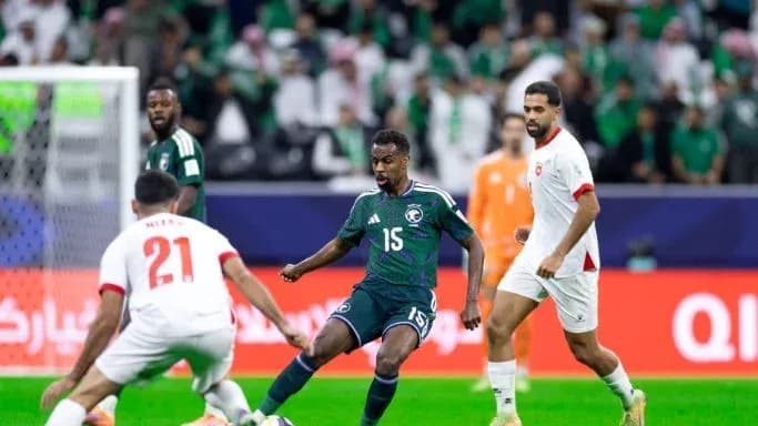 Jugador saudí eludiendo a dos rivales en el partido
