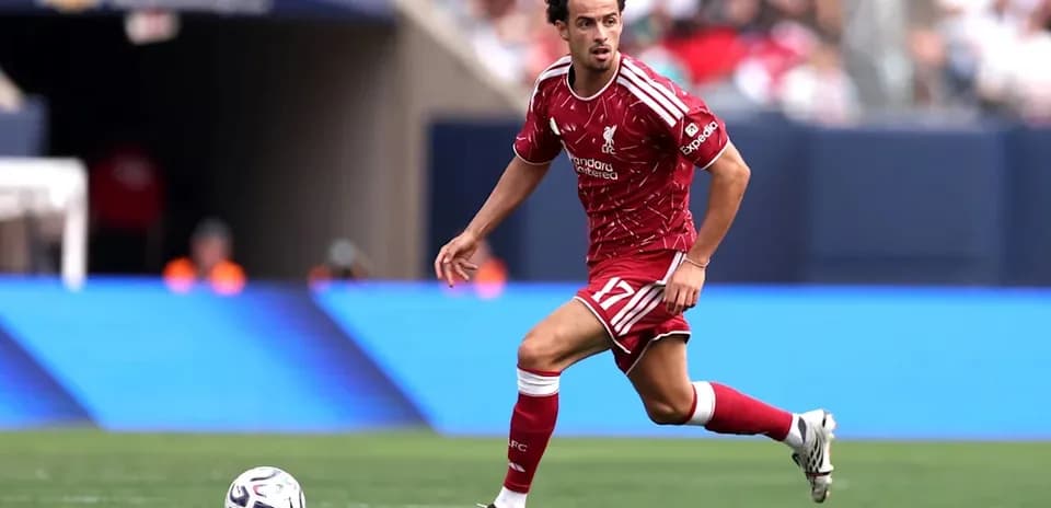 Jugador de Liverpool corriendo con el balón en el campo