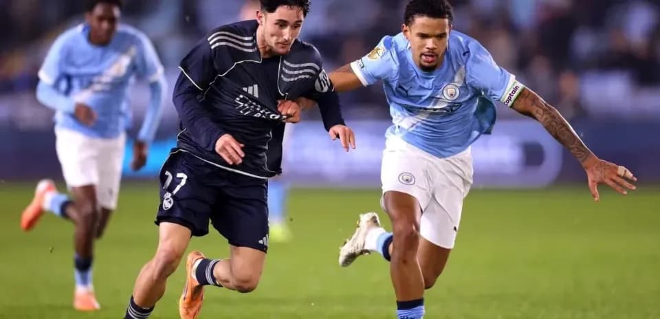 Jugador de Real Madrid corriendo con balón, seguido por jugador de Manchester City