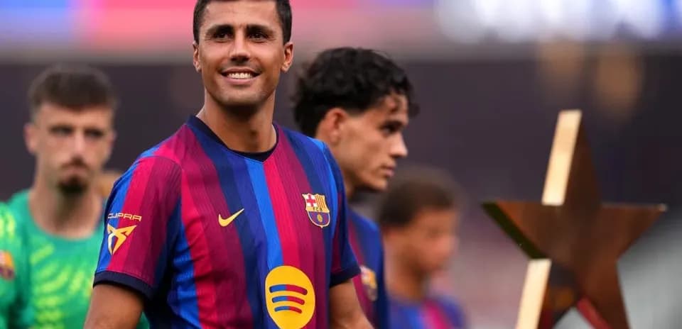 Jugador de Barcelona posando con trofeo en el campo