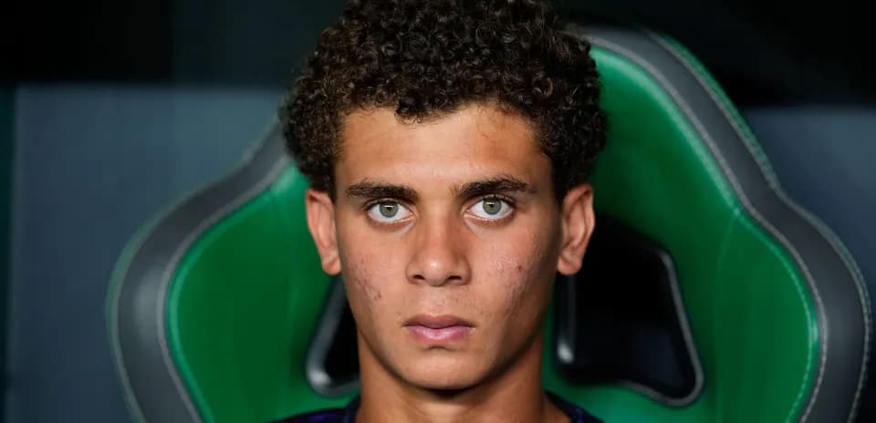 Joven jugador sentado en un banquillo deportivo