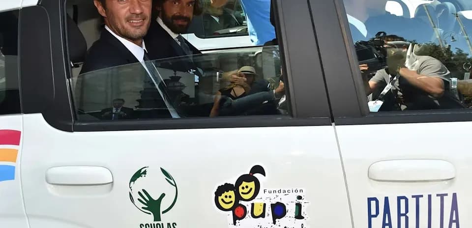 Dos hombres sentados en un coche con logos visibles