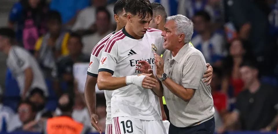 Entrenador hablando con jugador en el banquillo