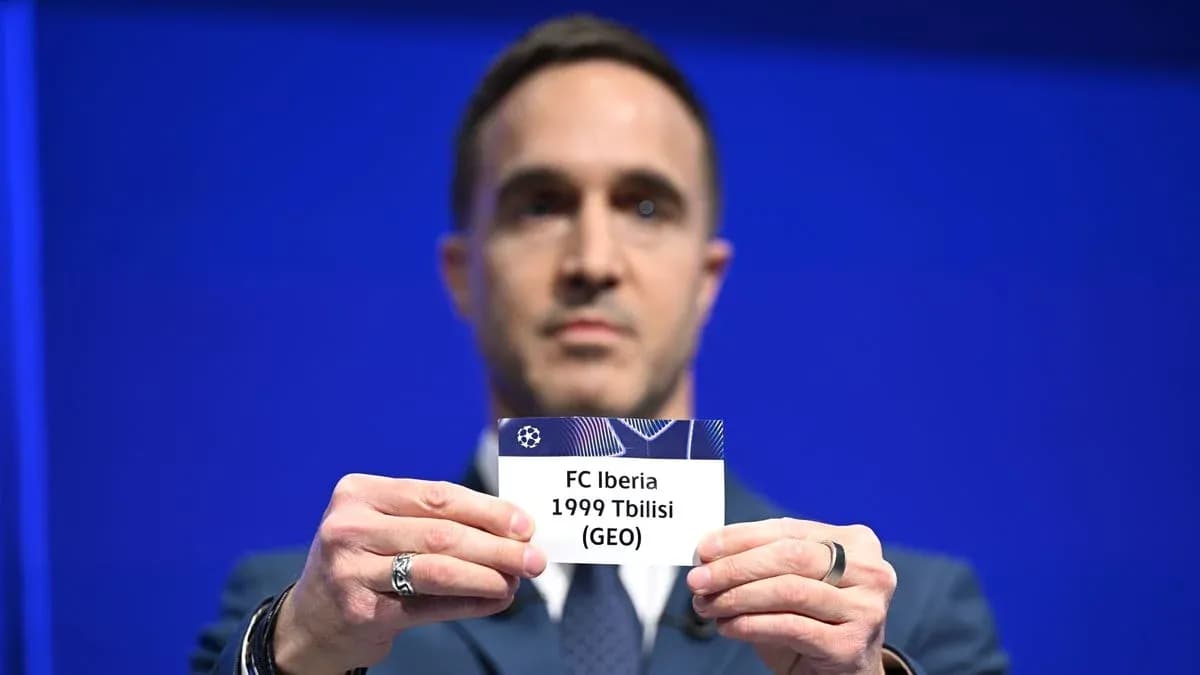 Hombre sosteniendo una tarjeta de FC Iberia 1999 Tbilisi