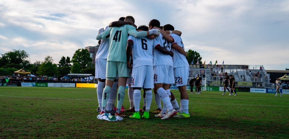 Equipo de fútbol en huddle antes del partido