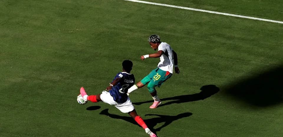 Jugador esquivando a oponente durante partido de fútbol