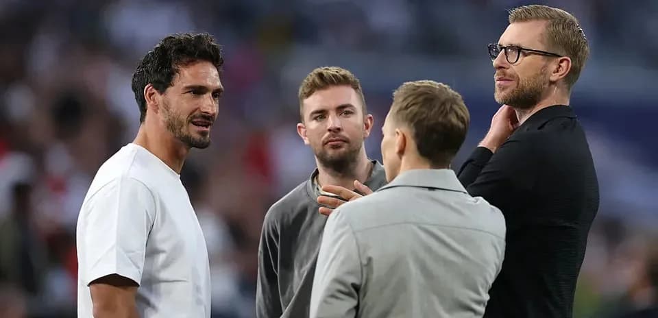 Cuatro hombres conversando en un evento deportivo