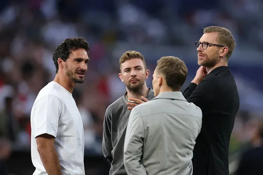 Cuatro hombres conversando en un evento deportivo
