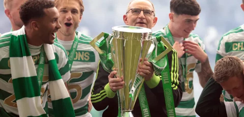 Jugadores y entrenador celebrando con el trofeo