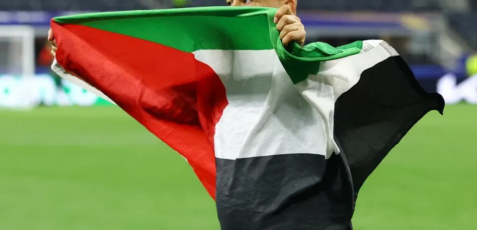 Hombre sosteniendo una bandera durante un evento deportivo