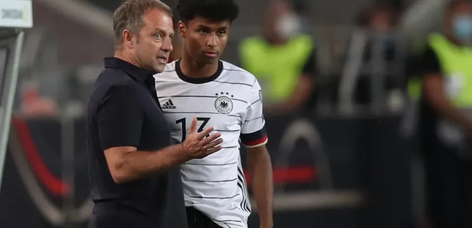 Entrenador hablando con jugador de Alemania en el campo