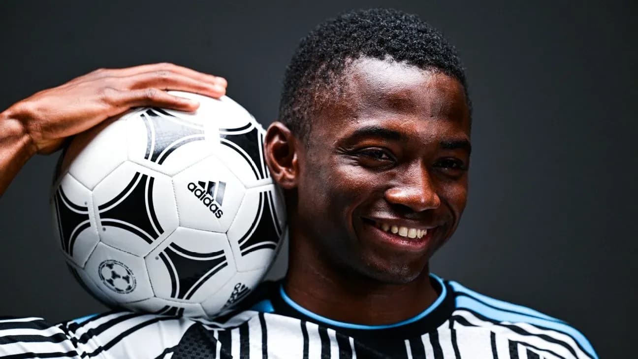 Jugador sosteniendo un balón de fútbol en hombro
