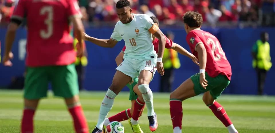 Jugador de Francia driblando entre defensores de Marruecos