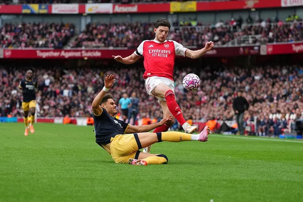 Un jugador de Arsenal salta sobre un oponente