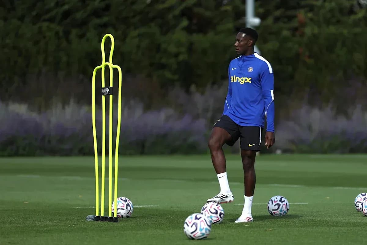 Jugador entrenando junto a conos y balones de fútbol