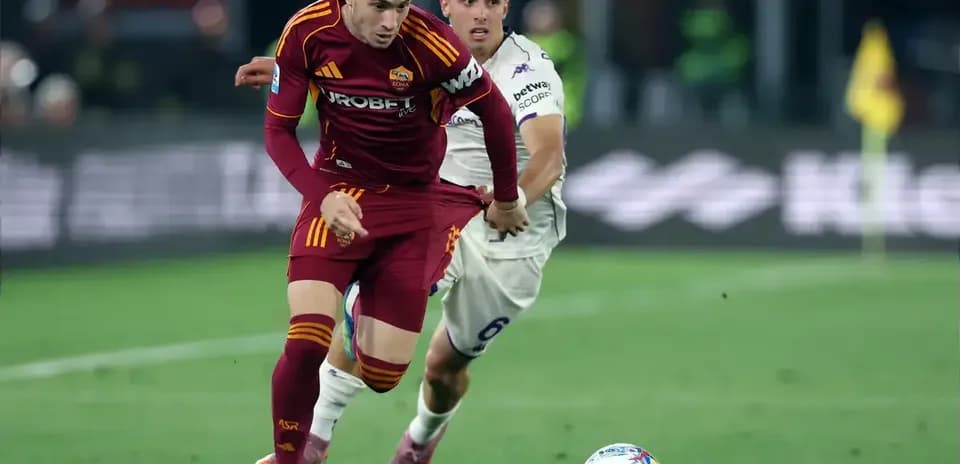 Jugador de la Roma driblando mientras es marcado
