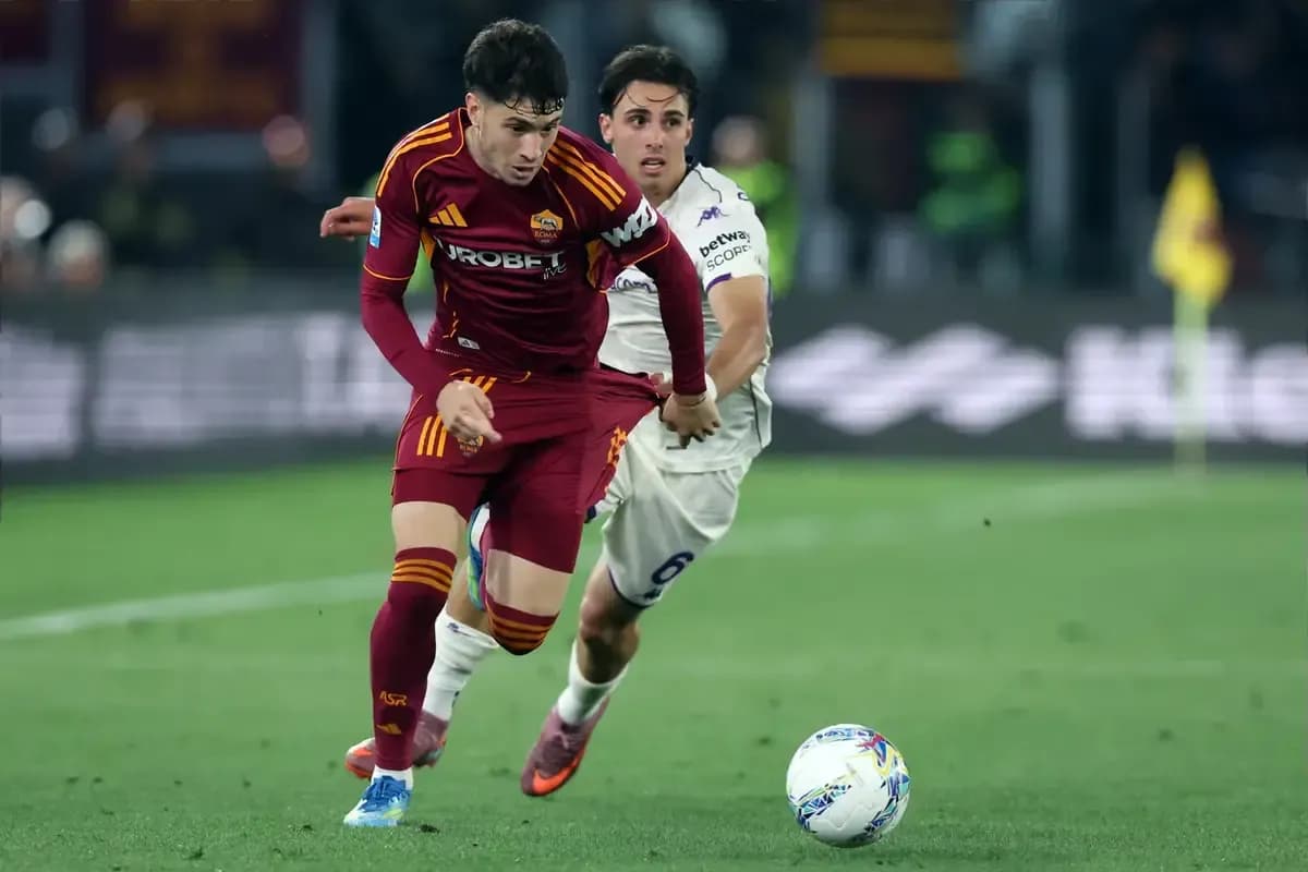 Jugador de la Roma driblando mientras es marcado