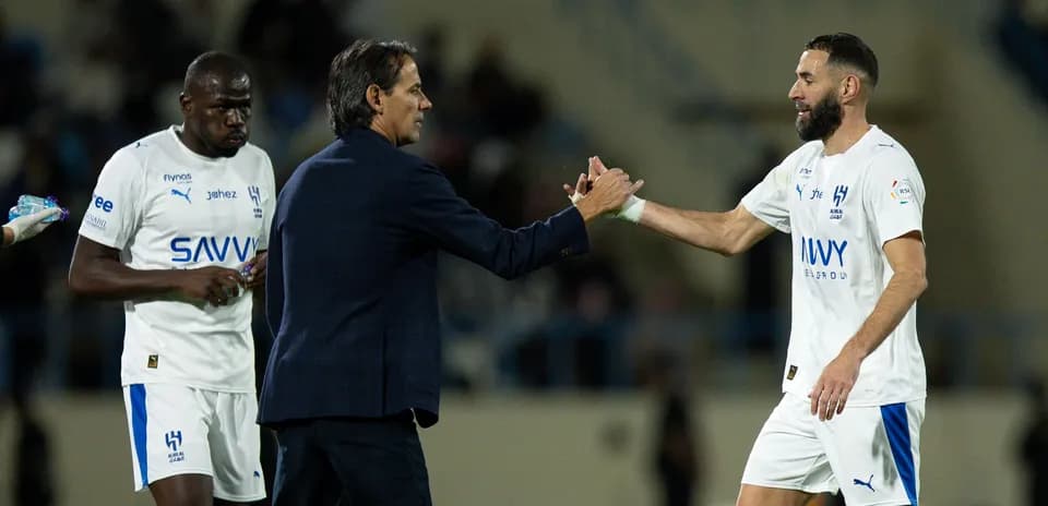 Entrenador saludando a jugador tras cambio en partido