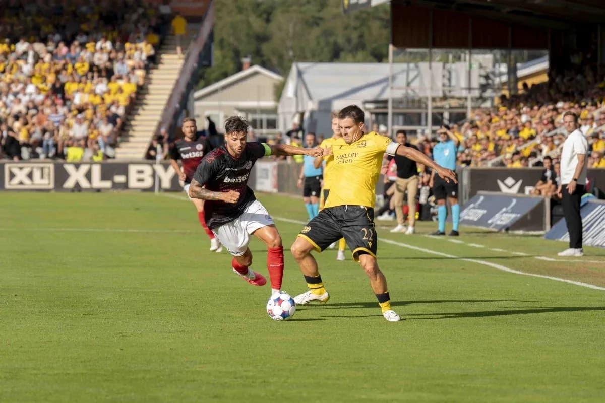 Dos jugadores compitiendo por el balón en el partido