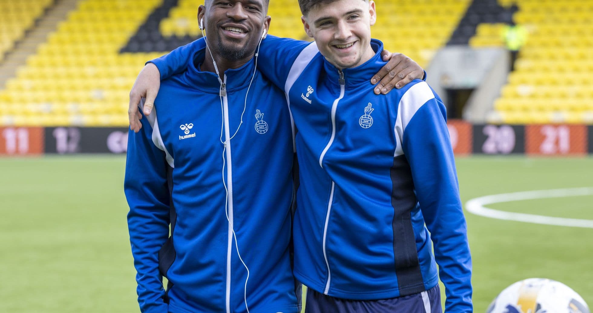 Dos jugadores sonriendo en el campo de entrenamiento