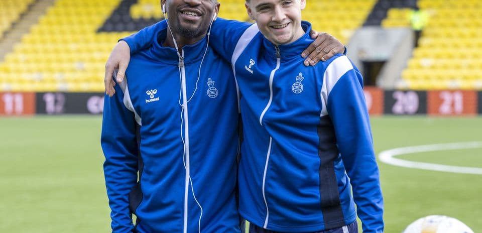 Dos jugadores sonriendo en el campo de entrenamiento
