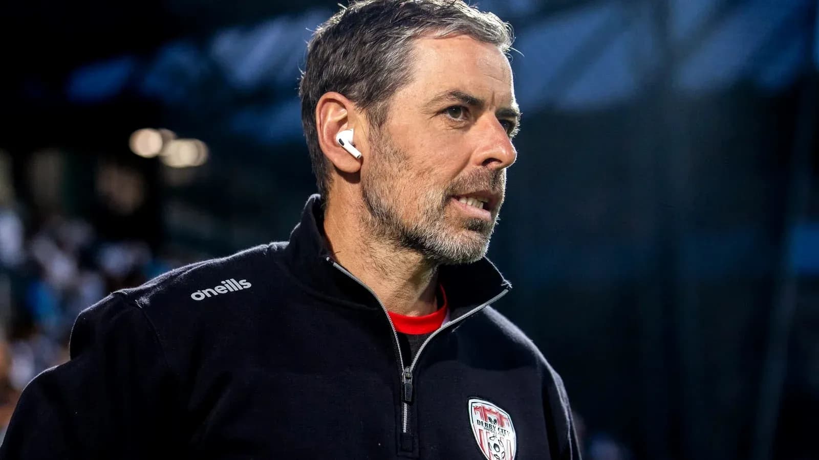 Entrenador con auriculares en el banquillo