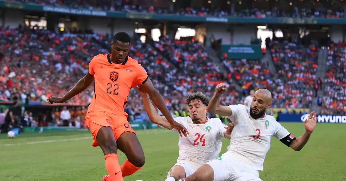 Jugador de Países Bajos driblando entre dos rivales