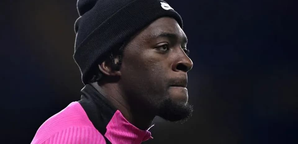 Jugador en calentamiento con sudadera rosa y gorro