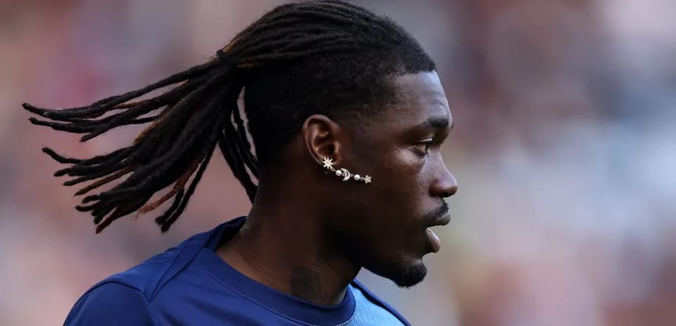 Jugador con trenzas y aretes en el campo