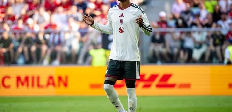 Jugador levantando las manos en el campo de fútbol