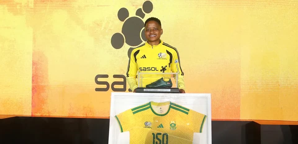 Jugador sosteniendo botines y camiseta en evento