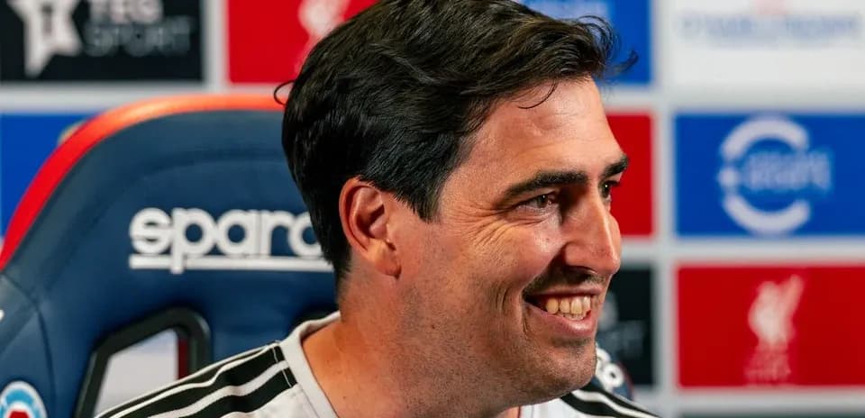 Entrenador en conferencia de prensa sonriente