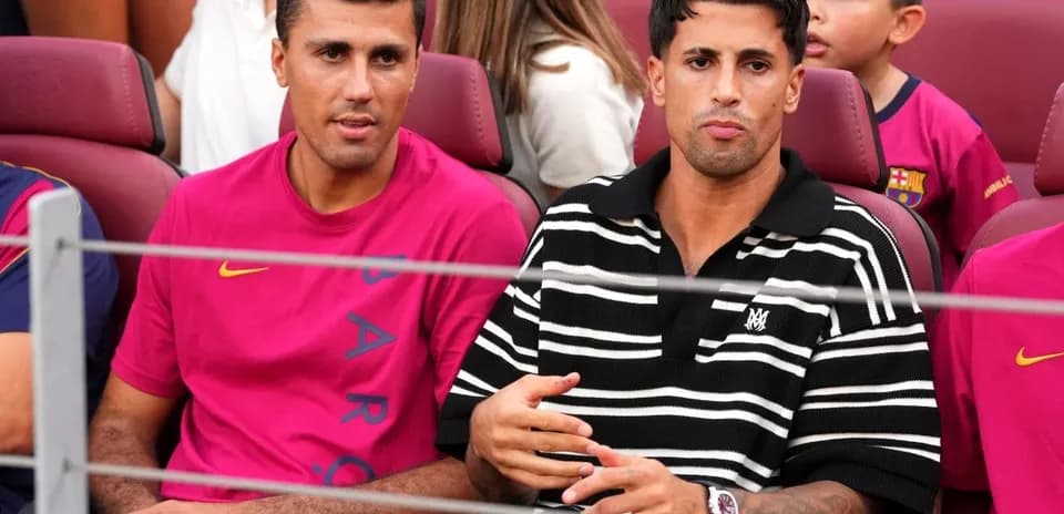 Dos jugadores sentados en el banquillo del estadio