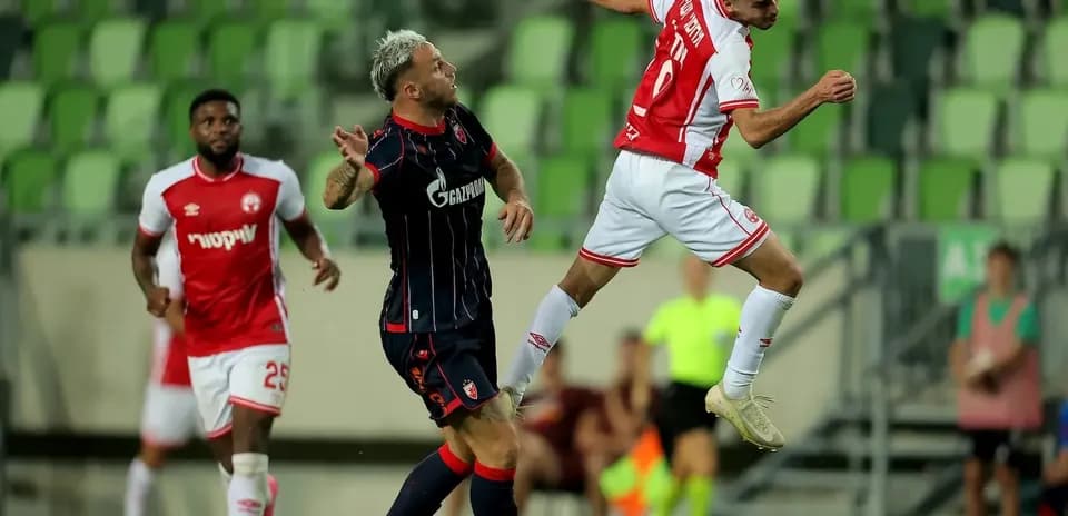Jugador de FK Crvena Zvezda saltando por el balón