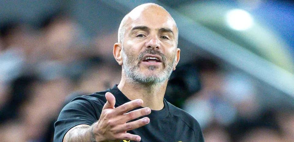 Entrenador gesticulando durante un partido de fútbol