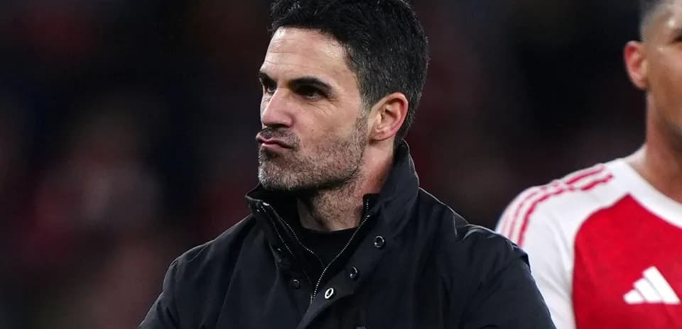 Entrenador de pie en el campo tras el partido