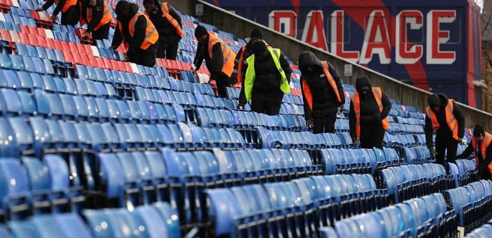 Trabajadores limpiando las gradas del estadio
